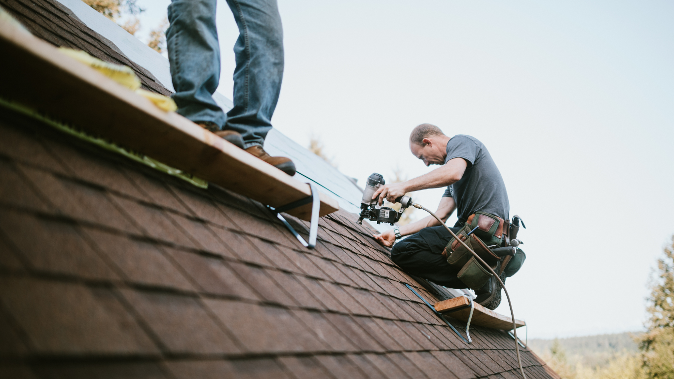 Two contractors undertaking roofing work.